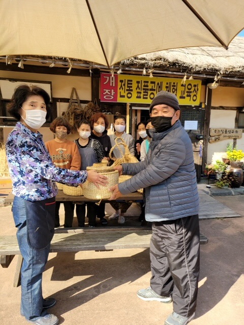 지난 9일 전통 짚풀공예 참여자들이 짚풀공예품 30여 점을 박종찬 위원장에게 기증하며 기념사진을 찍고 있다